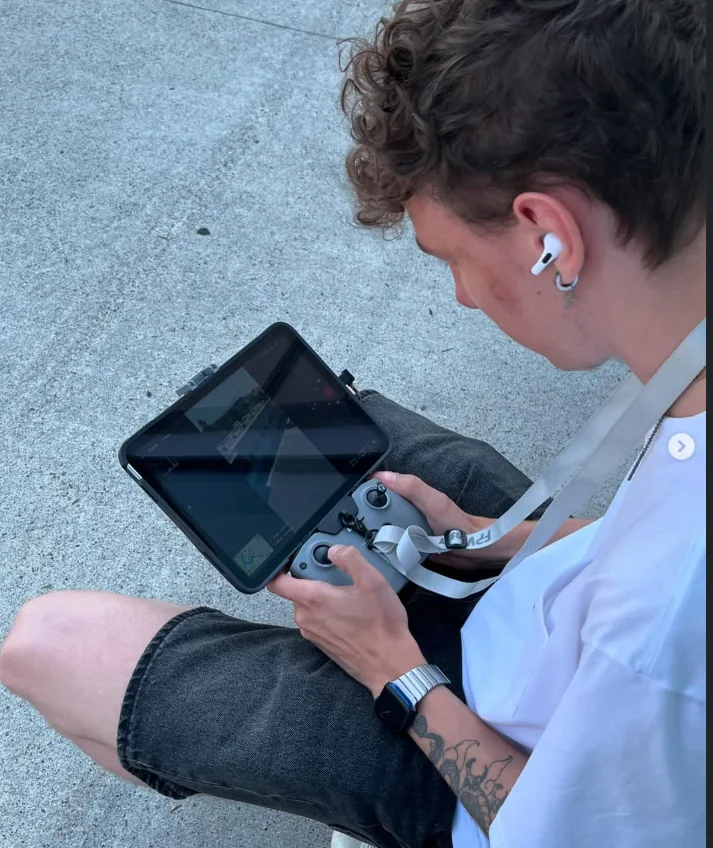 Tim operating a drone with a controller and tablet during the Optical One advertising shoot.